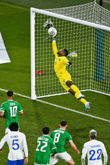 a soccer player with the number 22 on his jersey jumps to catch the ball