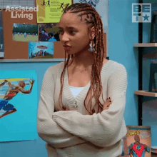 a girl with braids is standing with her arms crossed in front of a bulletin board that says assisted living