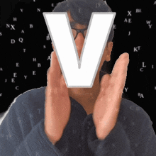 a man covering his face with a letter v