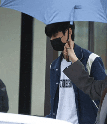 a man wearing a mask and a tokyo shirt