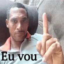 a man is sitting in a chair and giving the middle finger with the words eu vou written below him