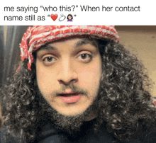 a man with curly hair and a beard is wearing a red and white hat