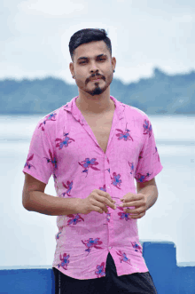 a man in a pink shirt with flowers on it