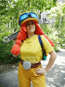 a woman wearing a yellow shirt that says своими руками