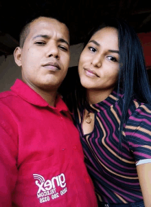 a man and a woman pose for a picture with the man wearing a red shirt that says auerp