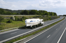 a jsw cement truck driving down a highway