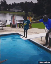 a boy is jumping into a swimming pool while a man holds his hand behind him