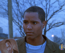 a man holding a picture of martin luther king jr. looks at the camera