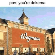 a picture of a wegmans store with a clock tower on top of it .