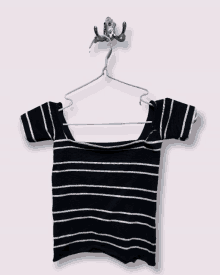 a black and white striped off the shoulder top is hanging on a hook