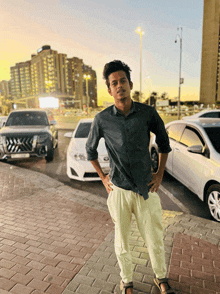 a young man stands in front of a row of cars including a toyota