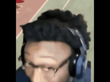 a close up of a person wearing headphones and glasses on a track .