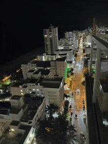 an aerial view of a city at night with lots of buildings lit up