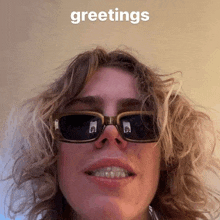 a man wearing sunglasses says greetings in the upper right corner