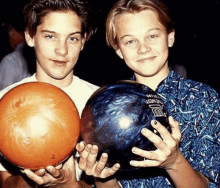 two young men are holding bowling balls one of which says challenger on it