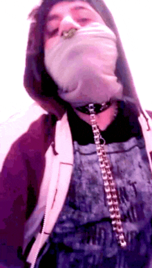 a person wearing a chain around their neck and a hoodie with a purple background