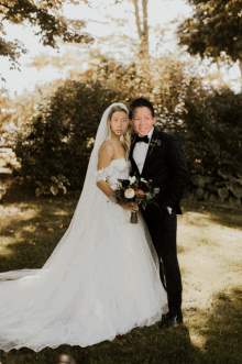 a bride and groom are posing for a picture in the grass