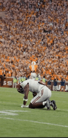 a football player with the number 11 on his jersey is kneeling down on the field