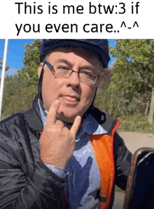 a man wearing a helmet and glasses is making a funny face with his finger on his chin .