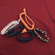 a bunch of different colored bracelets on a red surface