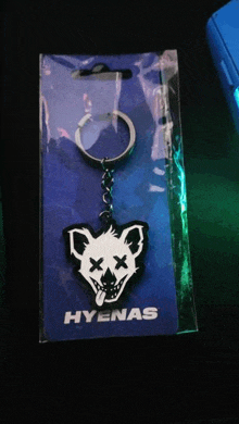 a keychain with a picture of a dead hyena and the word hyenas on it