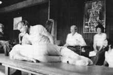 a black and white photo of a man giving a massage