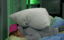 a person laying on a bed with a pillow on top of their head