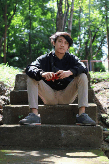 a young man sits on a set of concrete steps