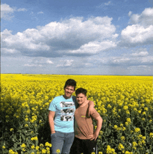 two men standing in a field of yellow flowers with one wearing a shirt that says ' reebok '