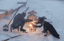 a group of warriors are huddled around a fire in the snow