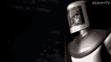 a robot with a helmet on is standing in a dark room with a blurred face .