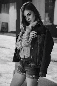 a black and white photo of a woman wearing shorts and a striped shirt