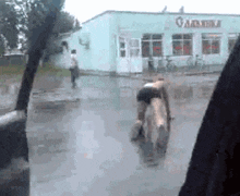 a man is riding a horse in front of a building that says ' gamakina ' on it