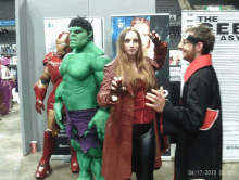 a hulk and scarlet witch pose for a photo with a man in a black robe