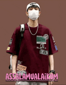 a man wearing a mask and a maroon shirt says " assalamualaikum " in pink