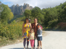 a group of people are posing for a picture in front of a mountain