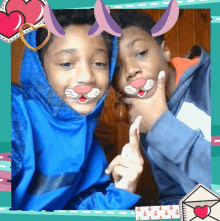 two boys wearing blue hoodies with bunny ears on their faces pose for a picture