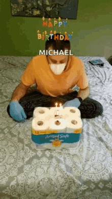 a man wearing a mask and gloves is sitting on a bed with a birthday cake made out of toilet paper