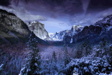 a snowy mountain landscape with trees and mountains in the background