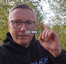 a man wearing glasses and a black hoodie has the words " jebie mnie to " above his face