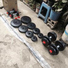 a row of dumbbells and a barbell are lined up on the ground