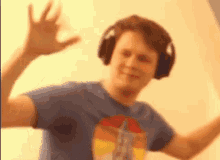 a man wearing headphones and a blue shirt is making a funny face .