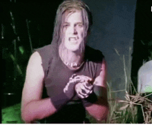 a man with long hair is wearing a black tank top with a snake on it .