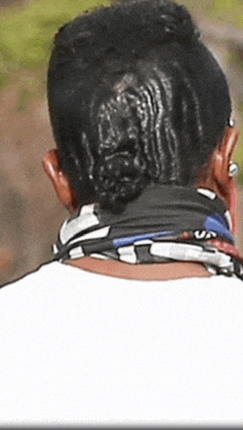 a close up of a person 's head with a bun and a scarf around their neck