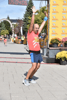 a man in a red shirt that says marathon on it stands in front of a yellow banner that says marathon on it