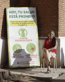 a woman sits in front of a sign that says hoy tu salud