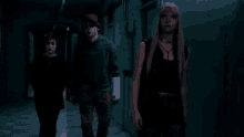 a group of people are walking through a dark hallway .