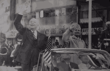 a black and white photo of two men waving in front of a building that says changers