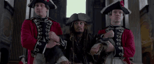 a man in a pirate costume is surrounded by two men