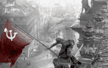 a black and white photo of a man raising a red flag with a hammer and sickle